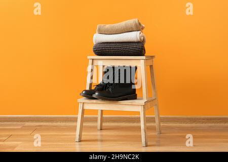 Stilvolle Winterkleidung auf der Leiter im Zimmer Stockfoto
