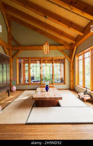 Lackierter Esstisch aus rustikalem Holz mit Tatami-Matten, schwarzem und braunem chinesischen Schrank, kleinen indonesischen Teakholztischen im japanischen Stil Stockfoto