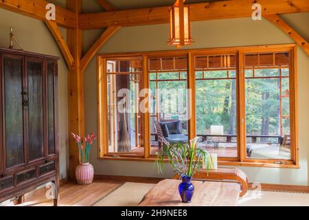 Lackierter Esstisch aus rustikalem Holz mit Tatami-Matten, schwarzem und braunem chinesischen Schrank und kleinem indonesischen Teakholztisch plus Blick auf das Home Office. Stockfoto