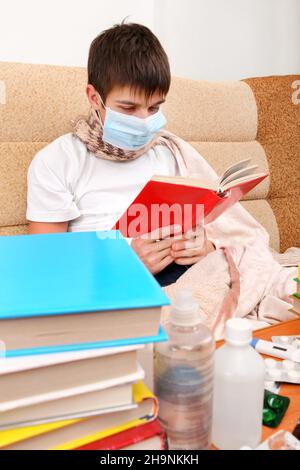 Kranker Teenager in Grippe-Maske mit den Büchern auf dem Sofa Stockfoto