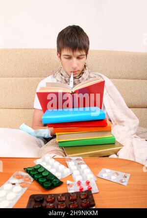 Kranker Teenager mit den Büchern auf dem Sofa Stockfoto
