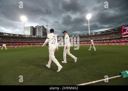 Englands Rory Burns ( links ) und Joe Root zwischen den Innings, während sich am ersten Tag des ersten Ashes-Tests in Gabba, Brisbane, Sturmwolken sammeln. Stockfoto