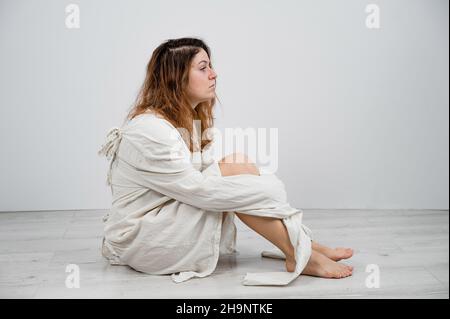 Nahaufnahme Porträt einer verrückten Frau in Zwangsjacke auf weißem Hintergrund. Stockfoto
