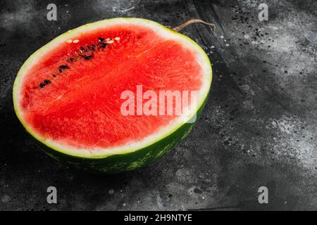 Stück Wassermelone, auf schwarzem dunklen Stein-Tischhintergrund, mit Platz für Text Stockfoto