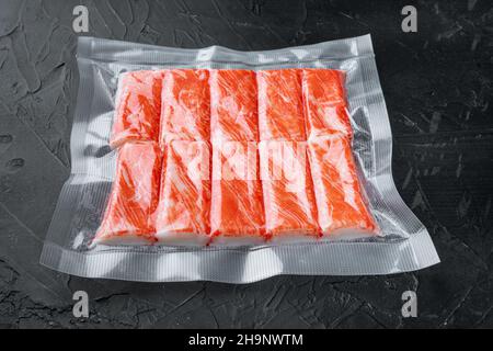 Krabbenfisch-Fleischstäbchen in Vakuumpackung, auf schwarzem Hintergrund Stockfoto