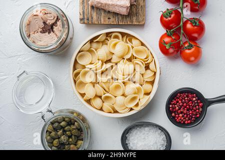 Köstliche Nudelgerichte mit Thunfisch und Kapern, auf weißem Hintergrund, Draufsicht Stockfoto