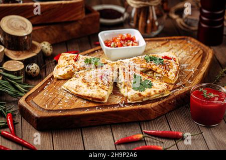 Hühnchen-Quesadilla mit Salsa-Sauce auf Servierbrett Stockfoto