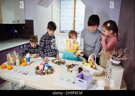 Mutter mit vier Kindern macht einen Kranz für Heiligabend und bastelt Dekoration. Neujahrsfest. Stockfoto