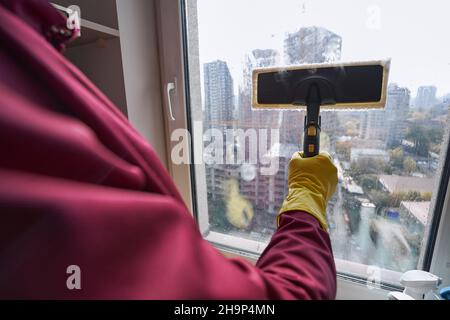 Professioneller Hausmeister mit Dampfreinigungsgerät für die Fensterreinigung Stockfoto