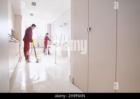 Zwei professionelle Reinigungskräfte, die in der Küche putzen Stockfoto
