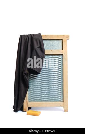 Waschbrett mit einem Stück Seife und schmutzigem Hemd auf weißem Hintergrund Stockfoto