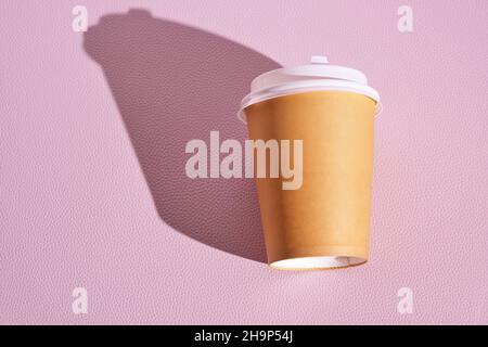 Einweg-Becher aus Papier für heißen Kaffee und Tee auf rosa Hintergrund.Konzept und Trend von Essen zum Mitnehmen Stockfoto
