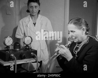 Szczawno Zdrój, 1949-02. Sanatorium. NZ. Kuracjuszka (mieszkanka wsi) w gabinecie fizjoterapii w trakcie zabiegu inhalacji pneumatycznej. Dok³adny dzieñ wydarzenia nieustalony. bk PAP Szczawno Zdroj, 1949. Februar. Sanatorium. Bild: Ein Patient (Dorfbewohner), der eine pneumatische Inhalationsbehandlung in einem Physiotherapieraum erhält. bk PAP Stockfoto