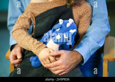 Leipzig, Deutschland. 08th Dez 2021. Ein 7-jähriges Mädchen sitzt auf dem Schoß ihres Dädchens und wartet darauf, gegen das Virus Covid19 geimpft zu werden. Die U12 Impfungen kommen in Sachsen langsam in Gang. Die Empfehlung der Ständigen Impfkommission (STIKO) zu Corona-Impfungen für Kinder zwischen fünf und zwölf Jahren steht noch aus. Derzeit wird der Impfstoff für Erwachsene noch immer speziell für Kinder in einer sogenannten „Off-Label-Anwendung“ dosiert. Quelle: Jan Woitas/dpa-Zentralbild/dpa/Alamy Live News Stockfoto