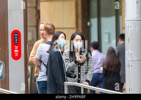 Covid 19 Omicron Fälle nehmen in Australien zu, zwei asiatische Damen tragen Gesichtsmasken an der Stadtbahnhaltestelle im Stadtzentrum von Sydney, Australien Stockfoto