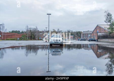 Kidderminster, Großbritannien. 8th. Dezember 2021. Britisches Wetter: Mit heftigem Regen am frühen Morgen beobachten die Einheimischen jetzt eine Ruhepause in den nassen Sachen. Aufgrund der starken Regenfälle kommen die Käufer auf den städtischen Parkplätzen an, wo sie nur begrenzt parken können. Dieses Auto steht allein auf einem wasserüberfluteten Parkplatz. Kredit: Lee Hudson/Alamy Live Nachrichten Stockfoto