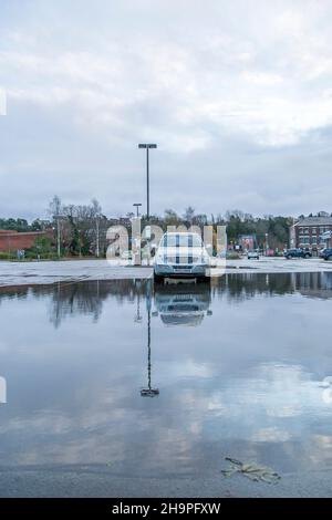 Kidderminster, Großbritannien. 8th. Dezember 2021. Britisches Wetter: Mit heftigem Regen am frühen Morgen beobachten die Einheimischen jetzt eine Ruhepause in den nassen Sachen. Aufgrund der starken Regenfälle kommen die Käufer auf den städtischen Parkplätzen an, wo sie nur begrenzt parken können. Dieses Auto steht allein auf einem wasserüberfluteten Parkplatz. Kredit: Lee Hudson/Alamy Live Nachrichten Stockfoto