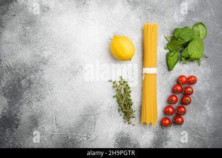 Rohzutaten zum Kochen italienischer Pasta, auf grauem Steintisch-Hintergrund, Draufsicht flach liegend, mit Platz für Text Stockfoto