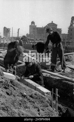 Warszawa, 1949-03. Budowa Trasy W-Z – ci¹gu komunikacyjnego Wschód-Zachód. NZ. Budowa jezdni ulicy Kapucyñskiej - uk³adanie krawê¿ników; w g³êbi gmach odbudowywanego Pa³acu Biskupów Krakowskich (P), koœció³ pw. œw. Anny wraz z dzwonnic¹ (C) oraz ruiny kamienicy przy ulicy Senatorskiej 3. mta PAP/Jerzy Baranowski Dok³adny dzieñ wydarzenia nieustalony. Warschau, März 1949. Der Bau der W-Z-Route (Ost-West-Kommunikationsleitung). Im Bild: Der Bau der Straße Kapucynska; im Hintergrund das Gebäude des Krakauer Bischofspalastes (im Umbau - rechts), Stockfoto