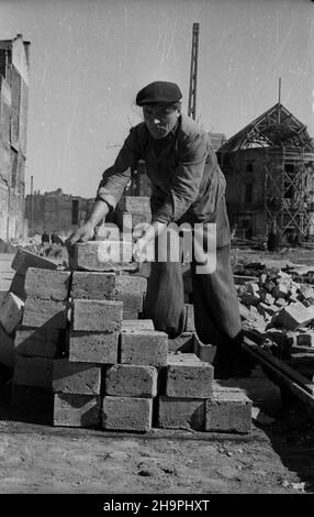 Warszawa, 1949-03. Budowa Trasy W-Z – ci¹gu komunikacyjnego Wschód-Zachód. NZ. Budowa jezdni i torowiska tramwajowego na T³omackiem (Róg ulicy Bielañskiej i T³omackiej) - prace brukarskie; w g³êbi XVIII-wieczny pa³ac Przebendowskich (Radziwi³³ów) przy ulicy Bielañskiej 14, odbudowywany po zniszczeniach wojennych wed³ug projectBruna Zborowski AP. Jerwalzendarnowski AP. Dok³adny dzieñ Warschau, März 1949. Der Bau der W-Z-Route (Ost-West-Kommunikationsleitung). Im Bild: Der Bau einer Straße und einer Straßenbahnlinie auf Tlomackie (Ecke Bielanska Stockfoto