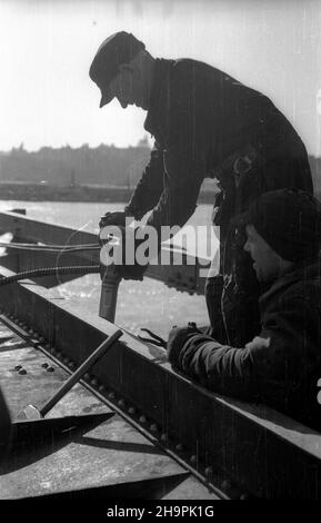 Warszawa, 1949-03. Budowa mostu Œl¹sko-D¹browskiego, przeprawy drogowej przez Wis³ê na Trasie W-Z (Trasa Wschód-Zachód). NZ. Budowa p³yty drogowej mostu, prace nitownicze; w g³êbi Stare Miasto. mta PAP Dok³adny dzieñ wydarzenia nieustalony. Warschau, März 1949. Der Bau der Slasko-Dabrowski Brücke über die Weichsel, Teil der W-Z (Ost-West) Route. Im Bild: Der Bau der Brückenstraße; Nieten; im Hintergrund die Altstadt. mta PAP Stockfoto