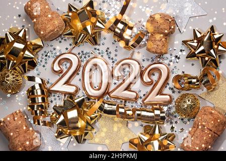 Urlaub Hintergrund Frohes neues Jahr 2021. Zahlen des Jahres 2022 von goldenen Kerzen auf Bokeh festlich funkelnden Hintergrund. Feiern Neujahr, Nahaufnahme. Platz für Text Stockfoto