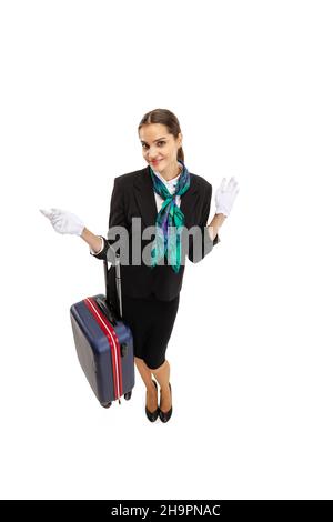 High-Angle-Ansicht der schönen jungen Mädchen, Flugbegleiter in Uniform mit Koffer isoliert auf weißem Studio Hintergrund. Stockfoto