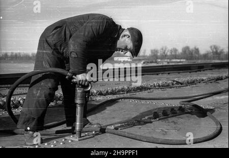 Warszawa, 1949-03. Budowa mostu Œl¹sko-D¹browskiego, przeprawy drogowej przez Wis³ê na Trasie W-Z (Trasa Wschód-Zachód). NZ. Budowa p³yty drogowej mostu, prace nitownicze; w g³êbi Park Praski. mta PAP Dok³adny dzieñ wydarzenia nieustalony. Warschau, März 1949. Der Bau der Slasko-Dabrowski Brücke über die Weichsel, Teil der W-Z (Ost-West) Route. Im Bild: Der Bau der Brückenstraße; Nieten; im Hintergrund Praski Park (links). mta PAP Stockfoto