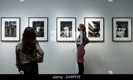 London, Großbritannien. 8. Dezember 2021. Mitarbeiter sehen sich Fotos in der Vorschau einer Ausstellung von verlorenen Fotos der Beatles von Lord Thynne, Sohn des Marquess of Bath aus dem Jahr 6th, an. Die Ausstellung mit offenen Bildern der Band im Frühjahr 1964 am Set ihres ersten Films A Hard Day’s Night findet bis zum 16. Januar 2022 in der Shapero Modern Gallery in Mayfair statt. Kredit: Stephen Chung / Alamy Live Nachrichten Stockfoto