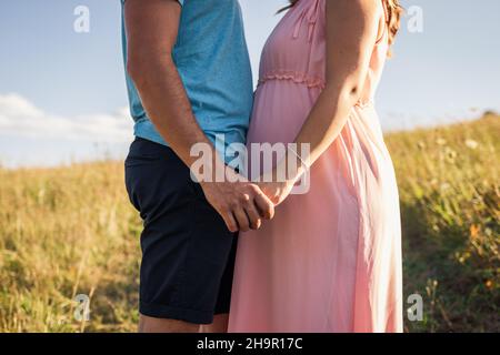 Junges Paar erwartet Baby. Eltern halten die Hände zusammen. Schwanger Frau mit ihrem Mann Stockfoto
