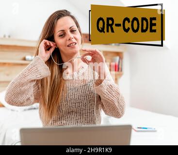 Schild mit QR-Code. Wort geschrieben auf der Marke für eine Art von Matrix-Barcode Ein maschinenlesbarer Code Frau vediözalling durch Laptop aus Stockfoto