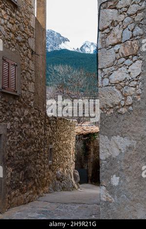 Schöne Aussicht auf verschneite Berge durch die Steinhäuser im Dorf Stockfoto
