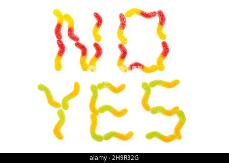 Worte JA und NEIN aus bunten Gummiwürmern, die auf weißem Hintergrund isoliert sind. Kauartikel und Zähne Gesundheit. Stockfoto