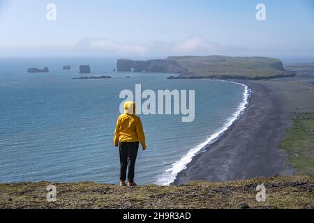 Junge Frau mit Blick auf Reynisfjara Beach, Black Sand Beach, Dyrholaey, Südisland, Island Stockfoto