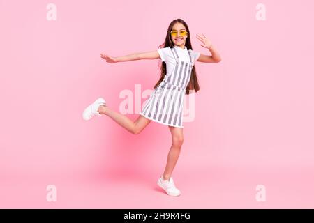 In voller Länge Körper Größe Foto schulmädchen insgesamt Gläser tanzen bei Party überglücklich isoliert pastellrosa Farbe Hintergrund Stockfoto