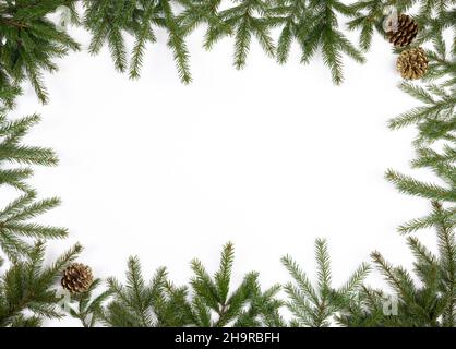 Einfacher Weihnachtsrahmen aus Tannenzweigen und Nadelholzzapfen auf weißem Hintergrund Stockfoto