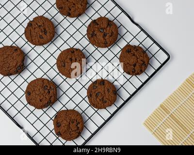 Chocolate Chip Cookies auf Kühlregal mit weißem Hintergrund. Guten Morgen, flach liegend, Draufsicht Stockfoto