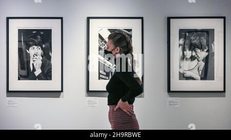 London, Großbritannien. 8th Dez 2021. Ein Mitarbeiter schaut sich die Bilder an. Nach 57 Jahren in Familienpapieren wiederentdeckt und aus Negativen entwickelt, sind verlorene Fotos der Beatles in einer seltenen Ausstellung in der Shapero Modern Gallery zu sehen. Der Fotograf Lord Thynne nahm im Frühjahr 1964 am Set ihres ersten Films A Hard Day's Night offene Aufnahmen der Band auf. Die Negative blieben 57 Jahre lang unentwickelt. Kredit: Imageplotter/Alamy Live Nachrichten Stockfoto