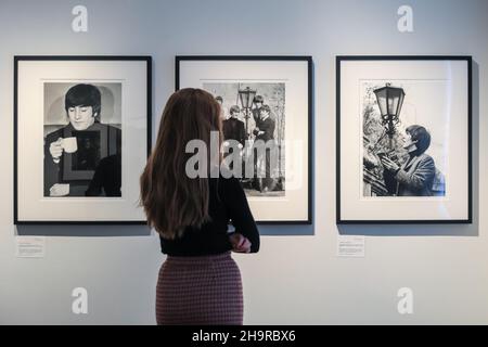 London, Großbritannien. 8th Dez 2021. Ein Mitarbeiter schaut sich die Bilder an. Nach 57 Jahren in Familienpapieren wiederentdeckt und aus Negativen entwickelt, sind verlorene Fotos der Beatles in einer seltenen Ausstellung in der Shapero Modern Gallery zu sehen. Der Fotograf Lord Thynne nahm im Frühjahr 1964 am Set ihres ersten Films A Hard Day's Night offene Aufnahmen der Band auf. Die Negative blieben 57 Jahre lang unentwickelt. Kredit: Imageplotter/Alamy Live Nachrichten Stockfoto