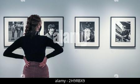 London, Großbritannien. 8th Dez 2021. Ein Mitarbeiter schaut sich die Bilder an. Nach 57 Jahren in Familienpapieren wiederentdeckt und aus Negativen entwickelt, sind verlorene Fotos der Beatles in einer seltenen Ausstellung in der Shapero Modern Gallery zu sehen. Der Fotograf Lord Thynne nahm im Frühjahr 1964 am Set ihres ersten Films A Hard Day's Night offene Aufnahmen der Band auf. Die Negative blieben 57 Jahre lang unentwickelt. Kredit: Imageplotter/Alamy Live Nachrichten Stockfoto