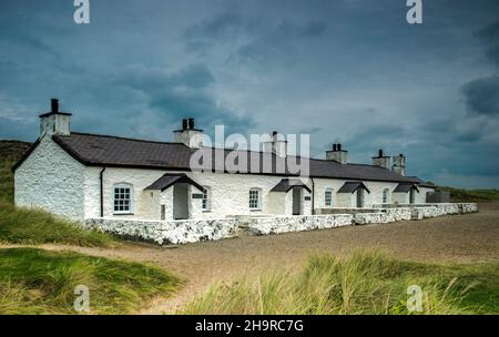 Reihe von Pilot Cottages auf Llanddwyn Island vor der Küste von Anglesey in der Nähe von Newborough Warren North Wales. Fotografiert im September Stockfoto