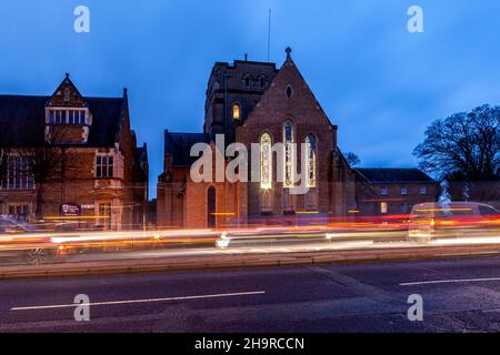 Barackstraße am späten Nachmittag mit Verkehrsbewegungen, die an der katholischen Kathedrale, Northampton, Northamptonshire, England, Großbritannien, vorbeiführen. Stockfoto