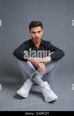 Porträt eines selbstbewussten jungen Mannes in schwarzem Hemd in voller Länge Stockfoto