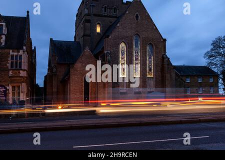 Barackstraße am späten Nachmittag mit Verkehrsbewegungen, die an der katholischen Kathedrale, Northampton, Northamptonshire, England, Großbritannien, vorbeiführen. Stockfoto