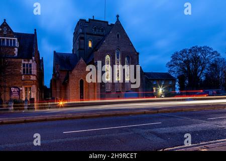 Barackstraße am späten Nachmittag mit Verkehrsbewegungen, die an der katholischen Kathedrale, Northampton, Northamptonshire, England, Großbritannien, vorbeiführen. Stockfoto