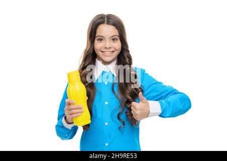 Glückliches Kind Daumen hoch Hand Geste hält gelbe Kunststoff-Trinkflasche, Genehmigung Stockfoto