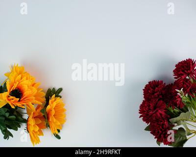 Künstliche Sonnenblumen und Nelken mit Kopierplatz auf weißem Hintergrund. Bereit, Text hinzuzufügen Stockfoto