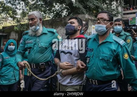 Dhaka, Bangladesch. 08th Dez 2021. Polizeibeamte eskortieren einen der 20 verurteilten Studenten nach ihrer Todesstrafe wegen des brutalen Mordes an einem jungen Mann aus dem Jahr 2019, der die Regierung in den sozialen Medien in Dhaka kritisierte, aus dem Gericht. Ein Gericht in Dhaka verurteilte am Mittwoch 20 junge Männer zum Tode und fünf zu lebenslanger Haft, weil sie im Oktober 2019 den 21-jährigen Abrar Fahad, einen Studenten der Elektrotechnik- und Elektronikindustrie an der Bangladesh University of Engineering and Technology (Buet), getötet hatten. (Foto: Sazzad Hossain/SOPA Images/Sipa USA) Quelle: SIPA USA/Alamy Live News Stockfoto