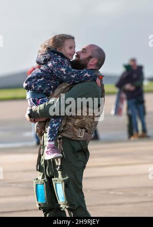 Familien aus 820 Geschwader vereinen sich nach der Rückkehr zur Luftstation Helston in Cornwall, die heute mit ihren sieben Merlin Mk2-Hubschraubern besetzt ist, wieder, waren rund 60 Flugzeugbesatzungen und Ingenieure aus der Geschwader, während die anderen getrennt zurückkehrten. Die Carrier Strike Group 2021 umfasst neun Schiffe aus verschiedenen alliierten Ländern, ein U-Boot, 32 Flugzeuge und mehr als 3.700 Mitarbeiter. Der Einsatz war ein wichtiger Meilenstein bei der Etablierung der globalen Fähigkeit des Vereinigten Königreichs, F35 Jets als Teil der konventionellen Abschreckung des Vereinigten Königreichs zu betreiben. Stockfoto