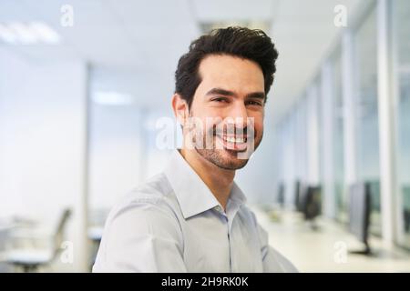 Lachender junger Geschäftsmann als Startup-Gründer im Büro Stockfoto